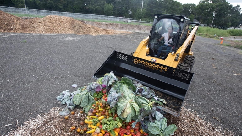 Glenda Alvarado-Ostrow moves discarded vegetables from a community farm into...