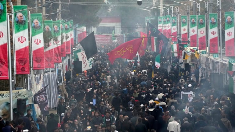 People walk on the street toward the grave of Iranian Revolutionary...