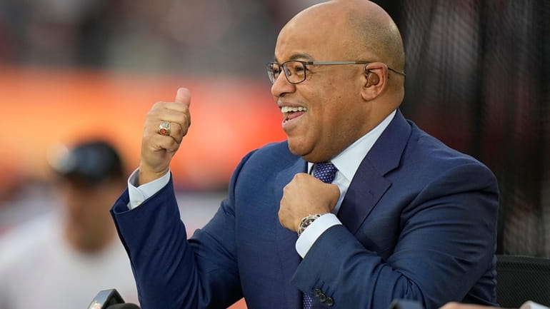 FILE -NBC broadcaster Mike Tirico motions to fans before the...