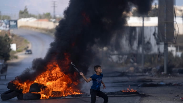 Palestinian demonstrators clash with Israeli forces following a demonstration in...