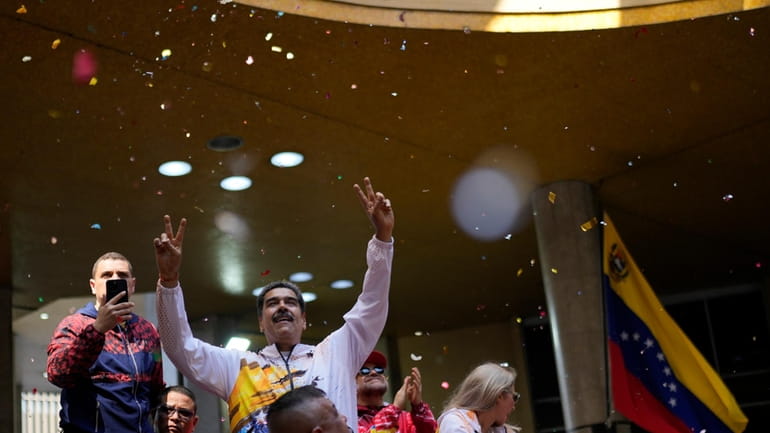 Venezuelan President Nicolas Maduro gestures to supporters as he arrives...
