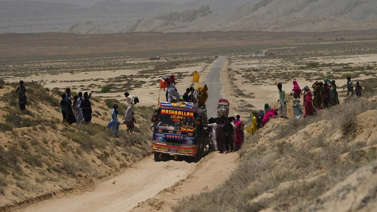Hindu devotees get off from a bus and walk toward...