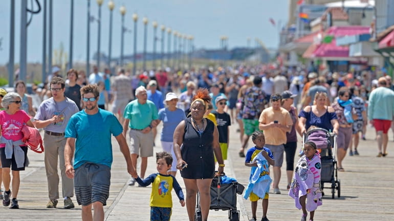 Locals and tourists walk along the mile-long boardwalk of City...