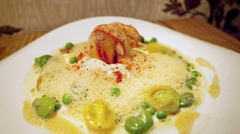 Butter poached lobster is served with creamy polenta, cherry tomatoes,...