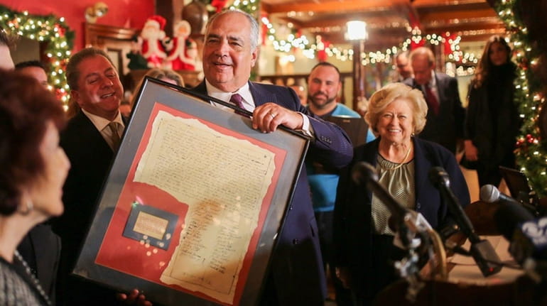 Anthony Capetola holds a reproduction of a marriage certificate dated...