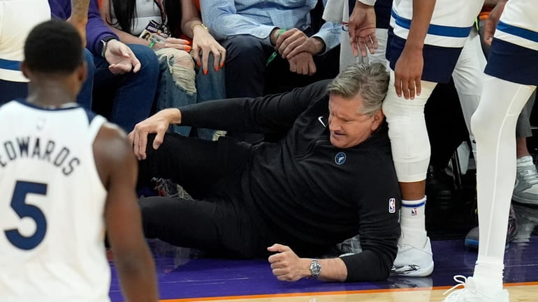 Minnesota Timberwolves head coach Chris Finch holds his knee after...