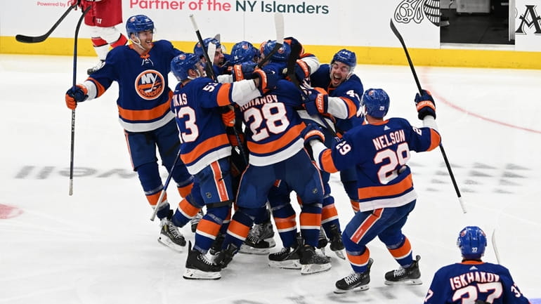 Islanders players celebrate their 3-2 overtime win against the Carolina...