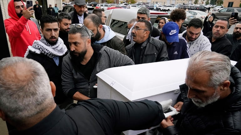 Family members of Wadea Al Fayoume bring his casket into...