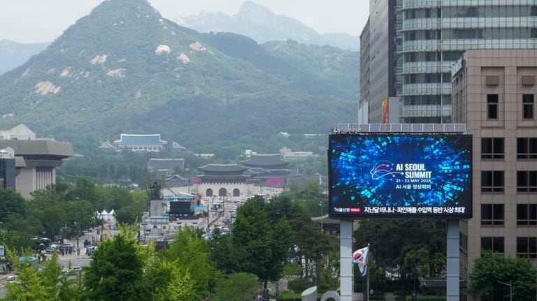 A screen shows an announcement of the AI Seoul Summit...