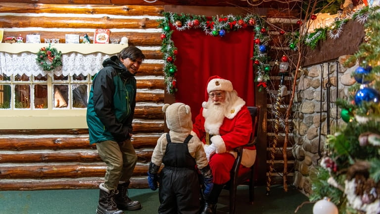 A visitor meets with Santa at the Lake Placid Holiday...