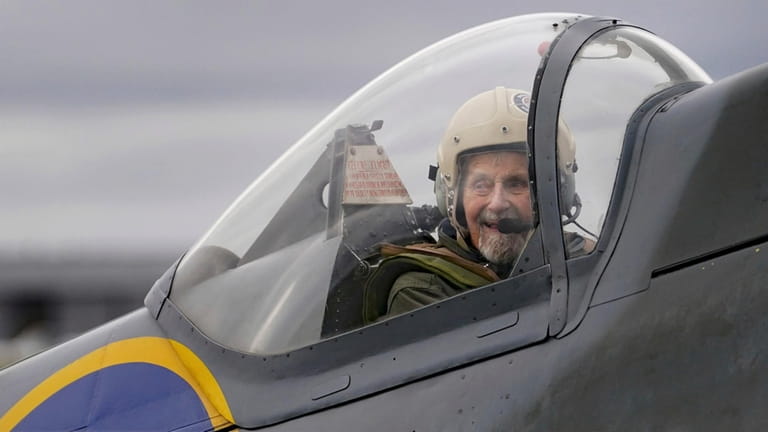 Jack Hemmings, 102, AFC, smiles after flying a Spitfire plane...