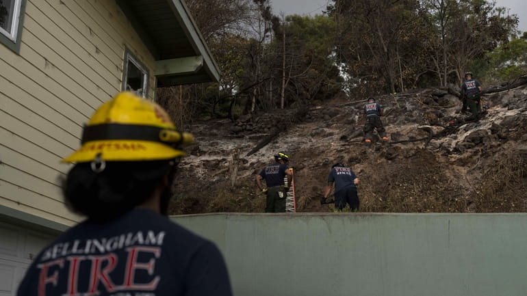 Firefighters clear debris in Kula, Hawaii, Tuesday, Aug. 15, 2023,...