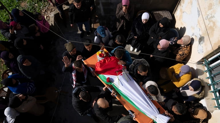 Mourners carry the body of Palestinian Abdel Rahman Hamed, 18,...