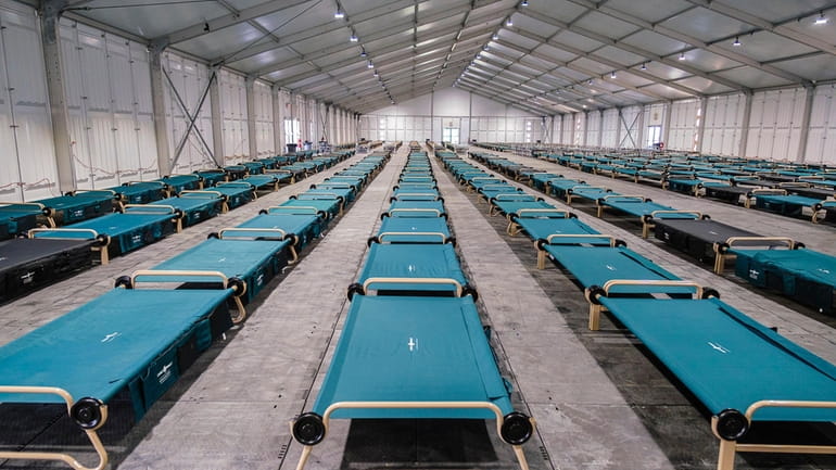 Cots await arrivals on opening day for new tent dorms...