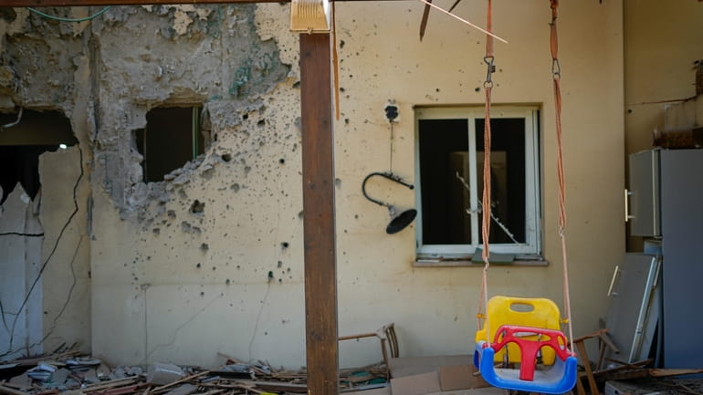 A children's swing hangs in a house damaged by Hamas...