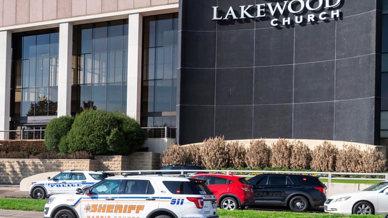 Emergency vehicles line the feeder road outside Lakewood Church during...