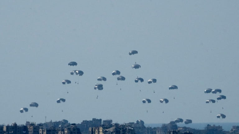 Parachutes drop humanitarian aid into the northern Gaza Strip, as...