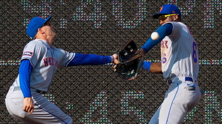Mets centerfielder Brandon Nimmo, left, and rightfielder Starling Marte cannot catch a...