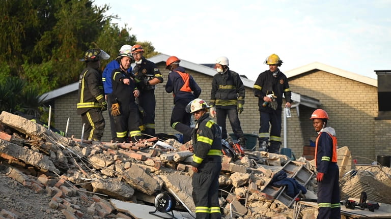 Emergency workers on the scene of a collapsed building in...