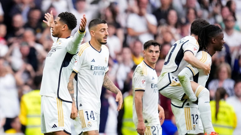 Real Madrid's Jude Bellingham, left, celebrates after scoring his side's...