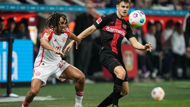 Bayern's Sacha Boey, left, and Leverkusen's Josip Stanisic challenge for...