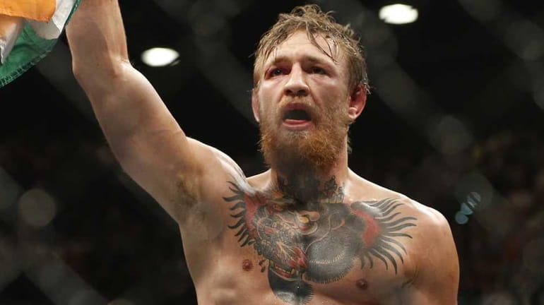 Conor McGregor celebrates after defeating Chad Mendes during their interim...