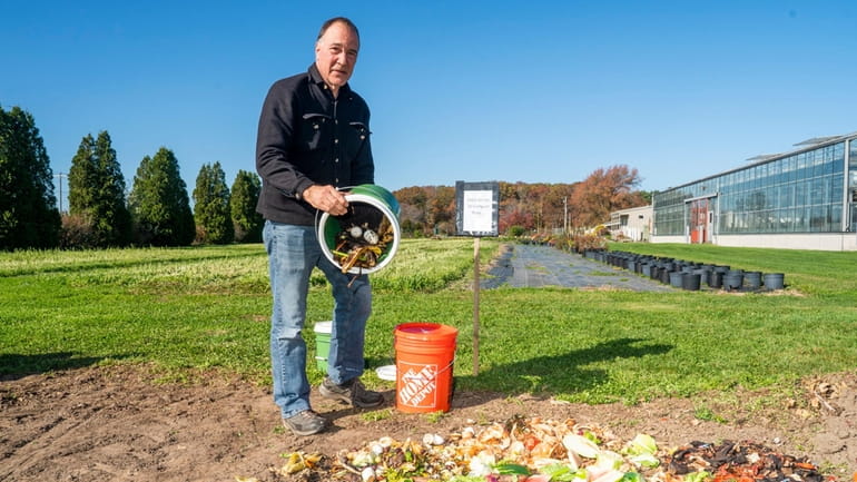 Drew Dillingham, Riverhead Town engineer, adds food scraps to a...