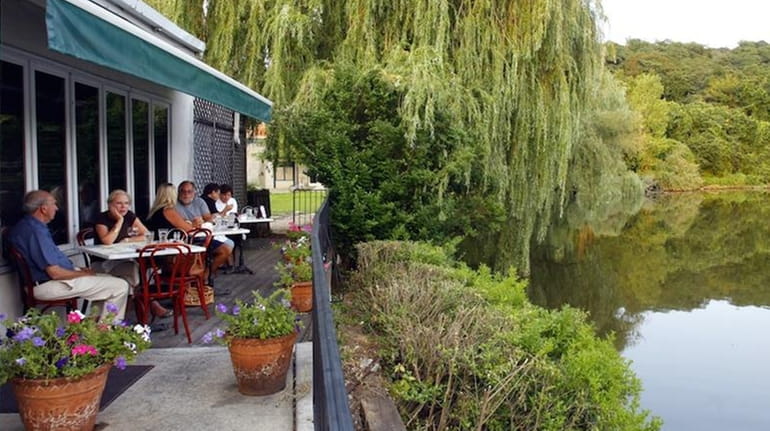 Diners enjoy the view of the Roslyn Duck Pond along...