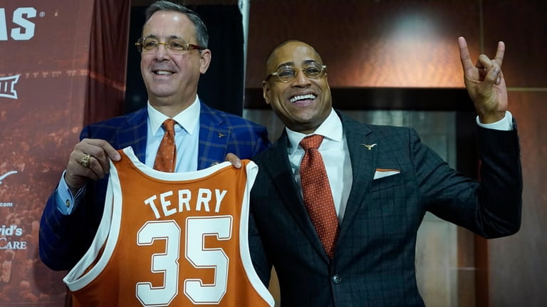 New Texas NCAA college basketball head coach Rodney Terry, right,...