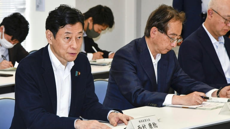 Japan's Industry Minister Yasutoshi Nishimura, left, meets with fisheries officials,...