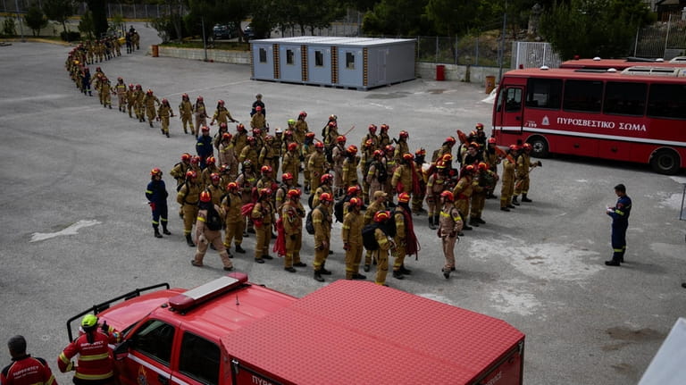 Firefighters in training for the special unit, gather after a...