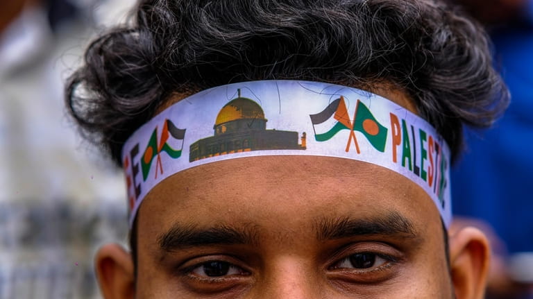 A student wearing headband looks on as Bangladeshi students march...