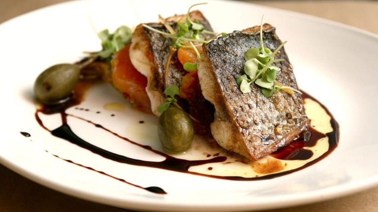 Venue 56's farm-raised striped bass, $29, is served with tomato...