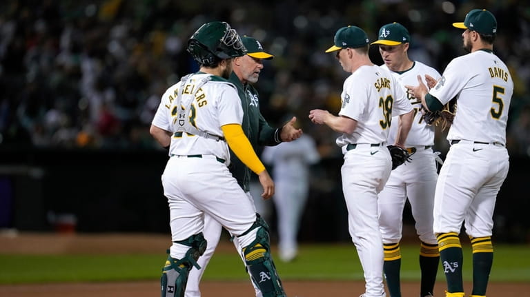 Oakland Athletics pitcher JP Sears (38) hands the ball over...