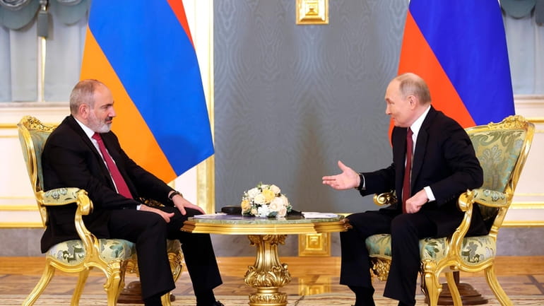 Russian President Vladimir Putin, right, gestures while speaking to Armenian...