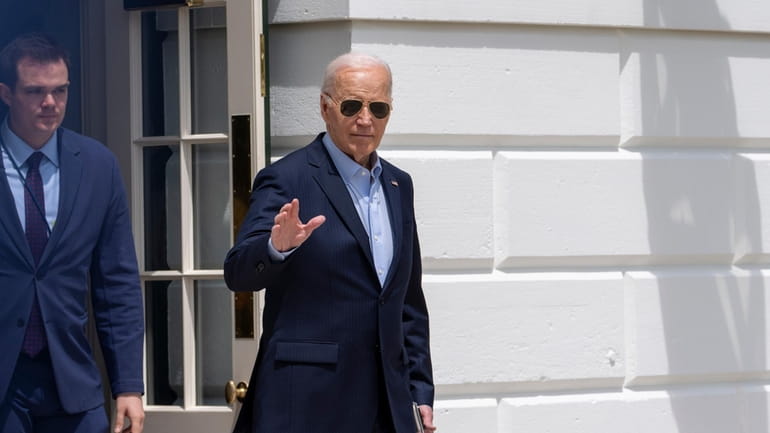 President Joe Biden waves as he walks to Marine One...