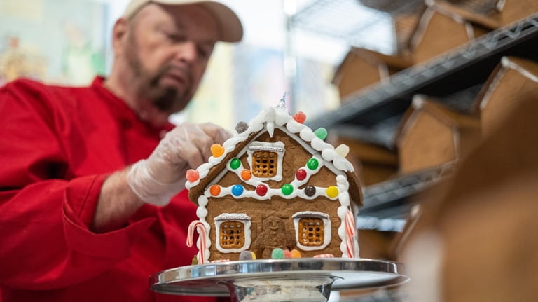 "Gingerbread Fred" Terry decorates a gingerbread house at Gingerbread University’s...