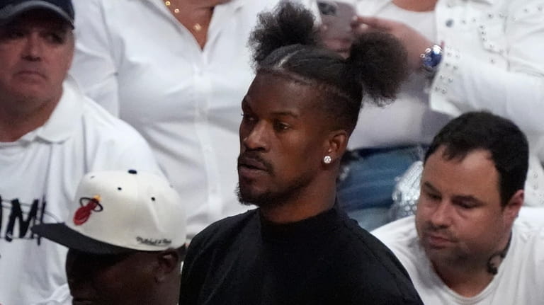 Miami Heat forward Jimmy Butler looks on from the bench...