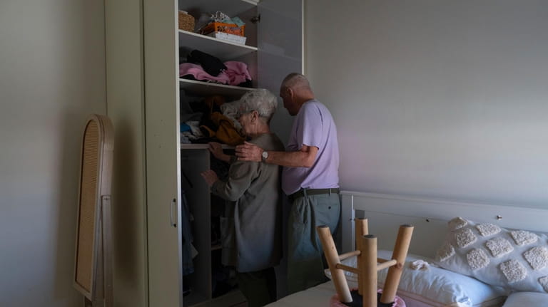 Pete and Gillian Brisley arrange clothes in their relatives’ home...