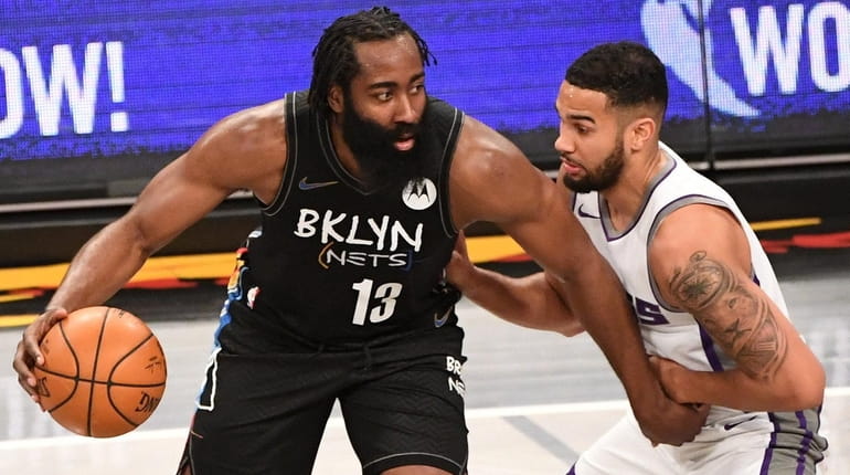 Nets guard James Harden is defended by Sacramento Kings guard...