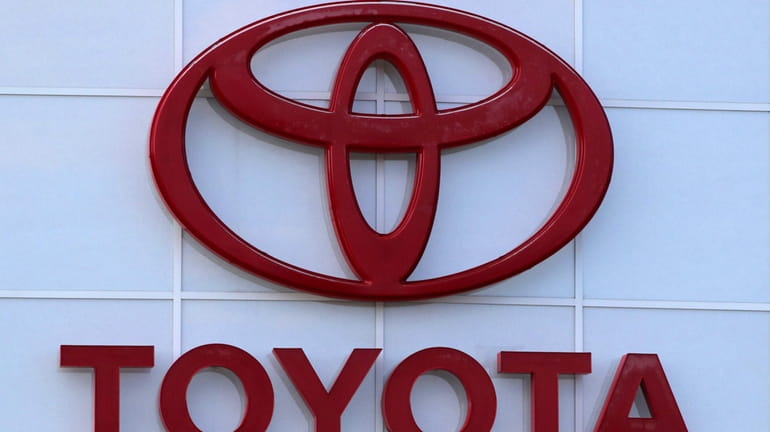The Toyota logo is shown on a dealership in Manchester,...