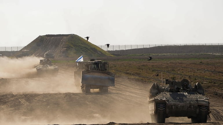 Israeli troops move near the Gaza Strip border in southern...