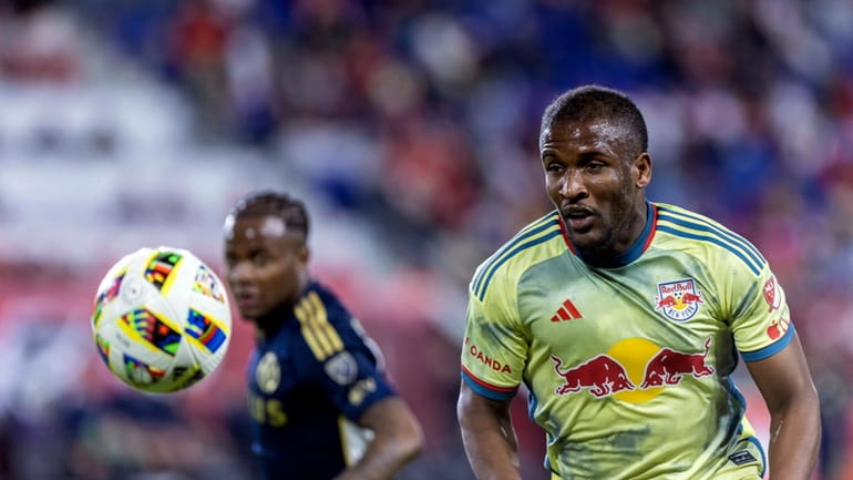 New York Red Bulls forward Elias Manoe, right,l chases the...
