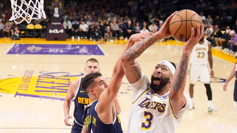 Los Angeles Lakers forward Anthony Davis, right, shoots as Denver...