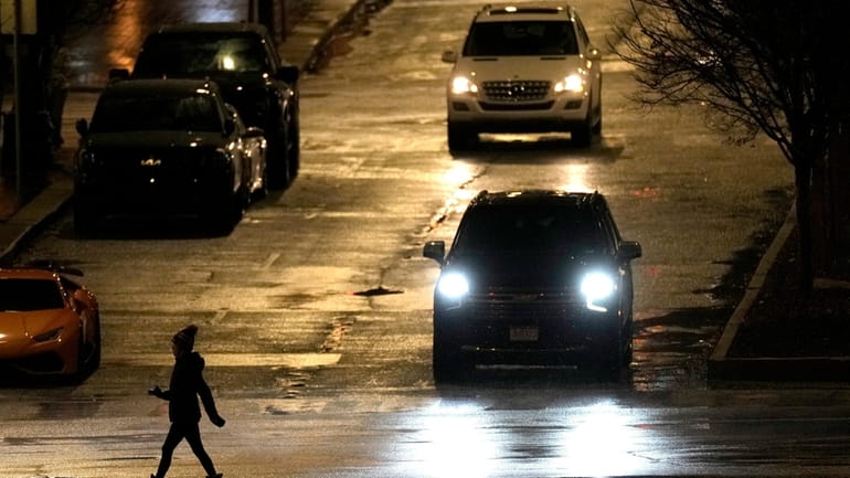 A pedestrian crosses a street in a shopping district Tuesday,...
