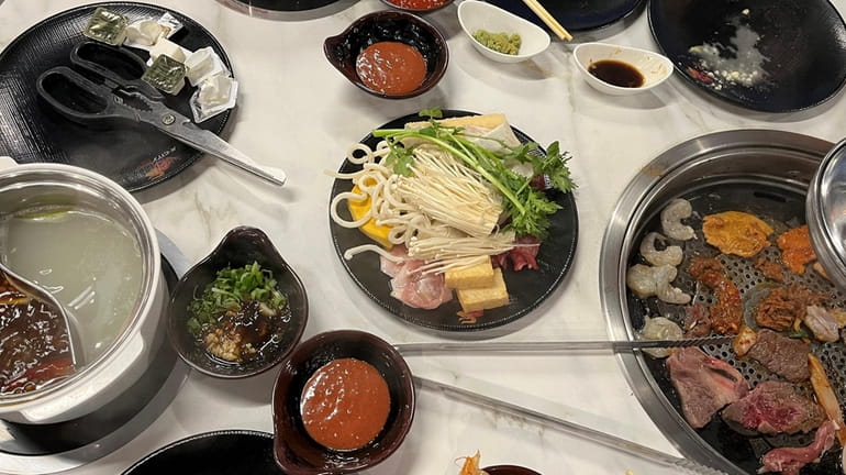 A table fills up with ingredients for Korean barbecue and...