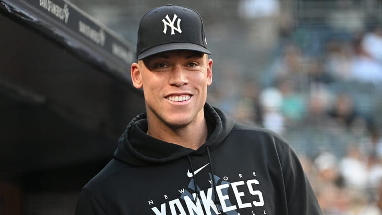 The Yankees' Aaron Judge looks on from the dugout before...
