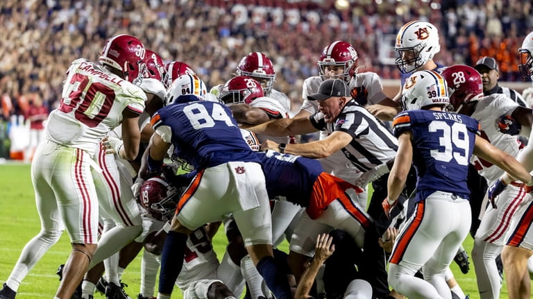 Referees try to break up an altercation between Alabama and...