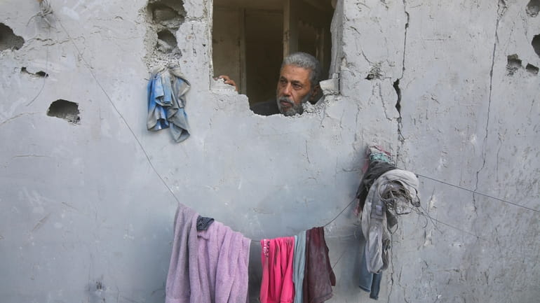 Palestinian looks from his house damaged by Israeli airstrikes in...