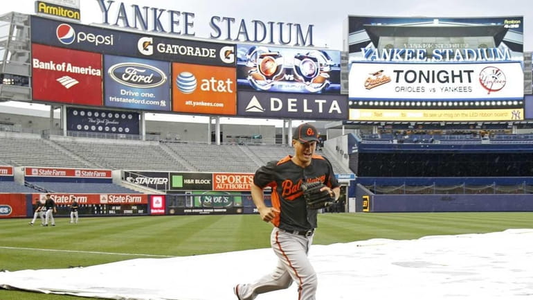 Baltimore Orioles starting pitcher Jeremy Guthrie dodges raindrops on his...